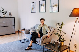 Gabinet terapeutyczny, terapeutka siedzi na fotelu, lampa w rogu